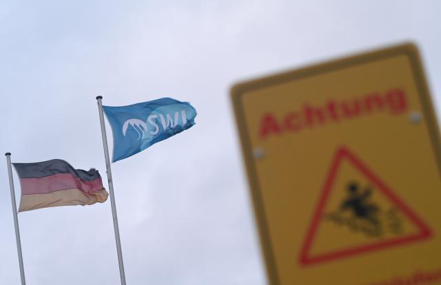 30 December 2024, Lower Saxony, Leer: A sign warns of the danger of falling while two flags fly in the background. The German Weather Service (DWD) has issued a warning of heavy squalls on the Brocken Peak and gusts of wind on the coast. Photo: Lars Penning/dpa