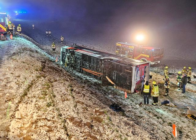 02 January 2025, Baden-Wuerttemberg, Hemmingen: Firefighters stand next to an overturned bus at the scene of an accident in the Ludwigsburg district. According to initial findings, several people were injured in the bus accident. Photo: Andreas Rosar/dpa