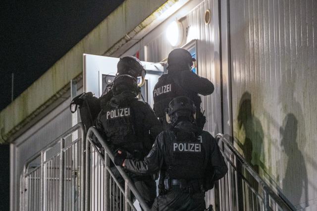 02 January 2025, Hamburg: Police officers break into a refugee shelter in the Neuenfelde district of Hamburg, where a brawl broke out there. According to current information, three people were injured. Photo: René Schröder/NEWS5/dpa