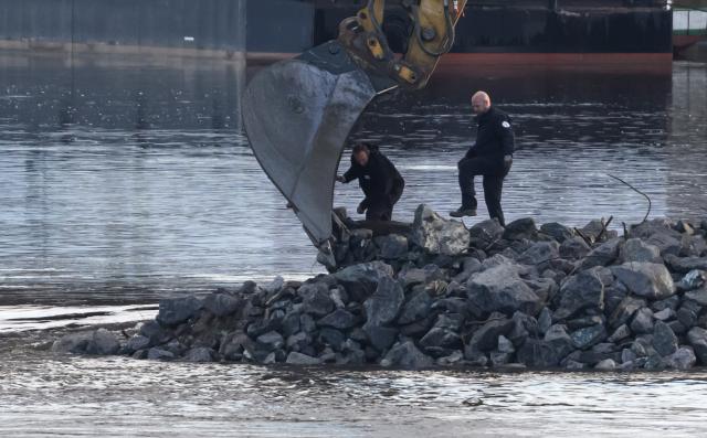 08 January 2025, Saxony, Dresden: Employees from the Explosive Ordnance Disposal Service stand in front of an excavator on the construction road for the demolition of the Carola Bridge. A bomb has been found during demolition work on the partially collapsed Carola Bridge in Dresden. Photo: Robert Michael/dpa