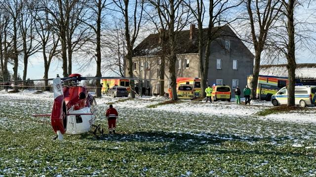 13 January 2025, Brandenburg, Casekow: Emergency services and a rescue helicopter stand in front of a house in Casekow, following a stabbing attack. A 26-year-old woman and a 16-year-old male were killed, while a 19-year-old woman was seriously injured. Police arrested a 27-year-old man, the suspect, with serious injuries. The motive remains unclear. Photo: Oliver Voigt/Märkische Oderzeitung/dpa