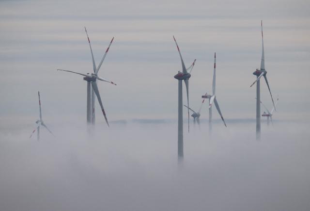 FILED - 05 December 2024, Rhineland-Palatinate, Freimersheim: Wind turbines protrude from a dense wall of fog near Freimersheim. Photo: Boris Roessler/dpa