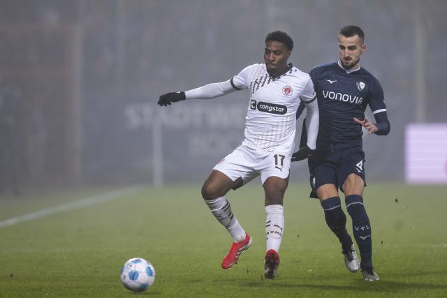 15 January 2025, Bochum: St. Pauli's Oladapo Afolayan (L) and Bochum's Erhan Masovic battle for the ball during the German Bundesliga soccer match between VfL Bochum 1848 and FC St. Pauli at Vonovia Ruhrstadion. Photo: David Inderlied/dpa - IMPORTANT NOTICE: DFL and DFB regulations prohibit any use of photographs as image sequences and/or quasi-video.