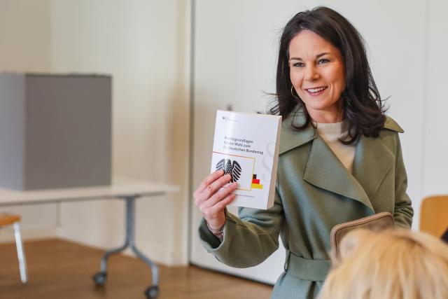 23 February 2025, Brandenburg, Potsdam: German Foreign Minister, Annalena Baerbock of the Alliance 90/The Greens, holds a book named "Legal Foundations for the 21st German Bundestag elections" during the German Federal election. Photo: Jan Woitas/dpa