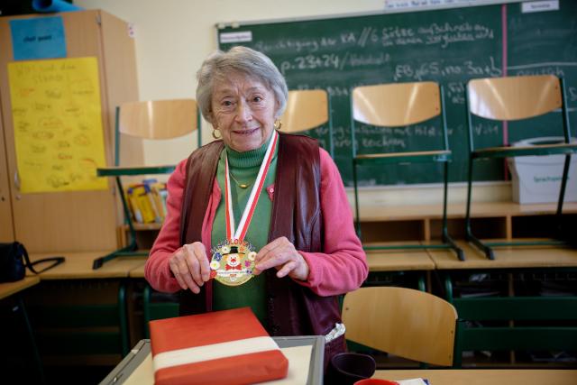 23 February 2025, North Rhine-Westphalia, Cologne: Cologne's oldest poll worker, Lydia Mors-Plattesat who is a 100 years old, stands in her polling station in Cologne-Rondorf, after receiving the Carnival Order of the City of Cologne from Cologne's Lord Mayor Reker. Photo: Henning Kaiser/dpa