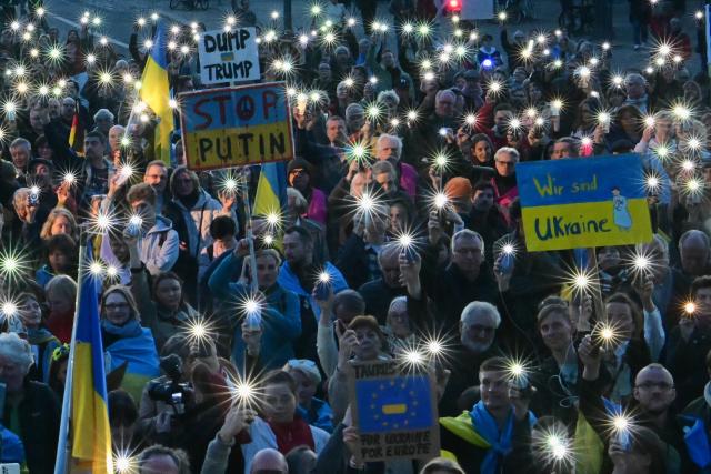 09 March 2025, Berlin: Participants hold up their smartphones during the demonstration "Stand with Ukraine" in solidarity with Ukraine, in front of the Brandenburg Gate. Photo: Sebastian Christoph Gollnow/dpa