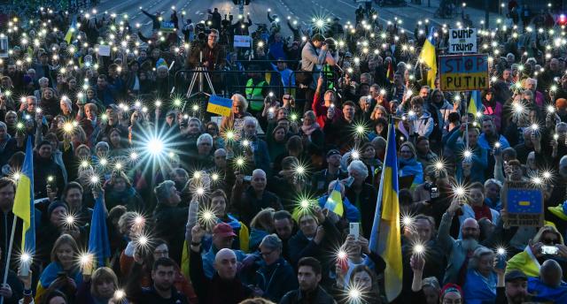 09 March 2025, Berlin: Participants hold up their smartphones during the demonstration "Stand with Ukraine" in solidarity with Ukraine, in front of the Brandenburg Gate. Photo: Sebastian Christoph Gollnow/dpa