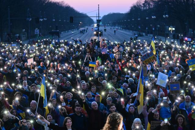 09 March 2025, Berlin: Participants hold up their smartphones during the demonstration "Stand with Ukraine" in solidarity with Ukraine, in front of the Brandenburg Gate. Photo: Sebastian Christoph Gollnow/dpa