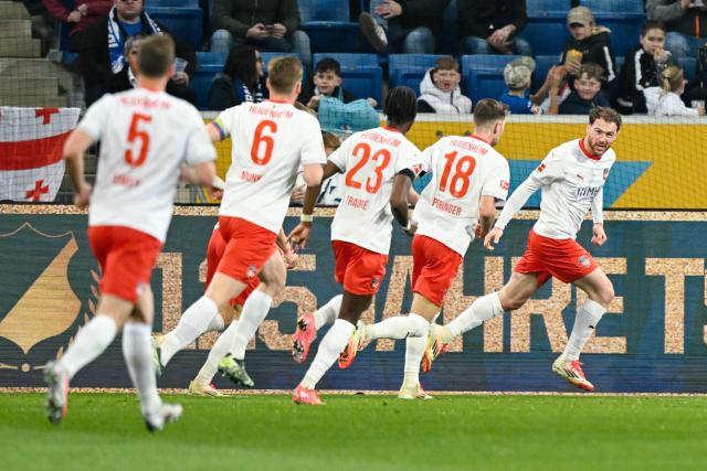 09 March 2025, Baden-Württemberg, Sinsheim: Heidenheim's Budu Zivzivadze (R) celebrates scoring his side's first goal with his teammates during the German Bundesliga soccer match between TSG 1899 Hoffenheim and 1.FC Heidenheim at PreZero Arena. Photo: Uwe Anspach/dpa - IMPORTANT NOTICE: DFL and DFB regulations prohibit any use of photographs as image sequences and/or quasi-video.