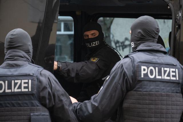 11 March 2025, North Rhine-Westphalia, Essen: Federal police officers take a man into custody during an operation. Following violence on a special train involving fans of third-division soccer club Hansa Rostock and Rot-Weiss Essen, the Federal Police have searched the homes of 31 suspects. Photo: Christophe Gateau/dpa