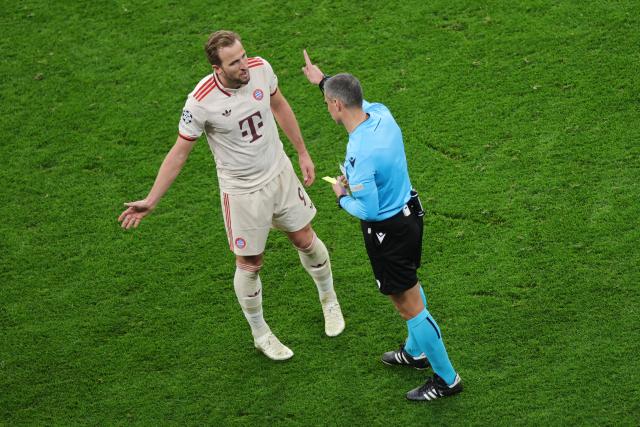 11 March 2025, North Rhine-Westphalia, Leverkusen: Munich's Harry Kane (L) talks to referee Slavko Vincic during the UEFA Champions League round of 16 second leg soccer match between Bayer Leverkusen and Bayern Munich at the BayArena. Photo: Rolf Vennenbernd/dpa