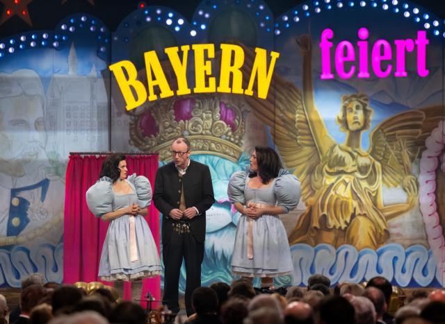 12 March 2025, Bavaria, Munich: Eli Wasserscheid (l-r, as deputy chairwoman of the CDU/CSU parliamentary group Baer), David Zimmerschied (as Friedrich Merz
) and Judith Toth (as Bavarian Agriculture Minister Kaniber) perform at the "Starkbieranstich" at Nockherberg. The strong beer season in Bavaria is traditionally opened with the traditional mocking, the "Derblecken" of politicians at Munich's Nockherberg. Photo: Sven Hoppe/dpa