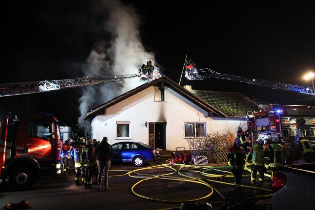 13 March 2025, Bavaria, Grossostheim: Firefighters work to extinguish afire at a house. Photo: Ralf Hettler/dpa