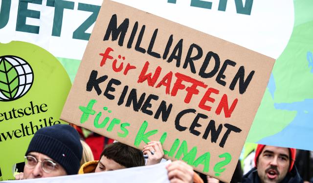 13 March 2025, Berlin: "Billions for weapons not a cent for the climate?" reads a sign held by Fridays for Future and Greenpeace activists during a protest against the new special fund in front of the Christian Democratic Union of Germany headquarters building Konrad Adenauer House in Berlin. Photo: Hannes P. Albert/dpa