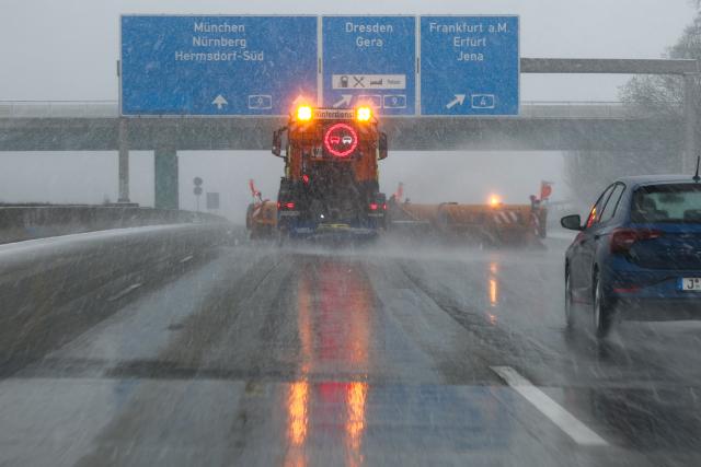 14 March 2025, Thuringia, Hermsdorf: A winter road maintenance vehicle operates on the A9 at the Hermsdorfer Kreuz junction as snowfall, sleet, and freezing temperatures return to parts of Saxony, Saxony-Anhalt, and Thuringia. Photo: Jan Woitas/dpa