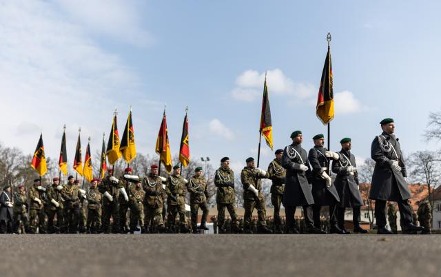 14 March 2025, Berlin: Soldiers depart the event carrying German flags as the army establishes a new homeland security division as its fourth major unit. Photo: Hannes P. Albert/dpa