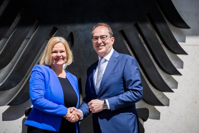07 May 2025, Berlin: Alexander Dobrindt, new German Minister of the Interior and Home Affairs, and his predecessor Nancy Faeser shake hands in front of the federal eagle at the protocol entrance to the Federal Ministry of the Interior during a photo session to mark the handover of office. Photo: Christoph Soeder/dpa