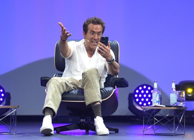 FILED - 06 May 2025, Hamburg: Ryan Reynolds, canadian actor, entrepreneur and co-owner of Welsh soccer club Wrexham AFC, gestures on stage during the OMR digital and marketing fair in the exhibition halls in Hamburg. Photo: Marcus Brandt/dpa