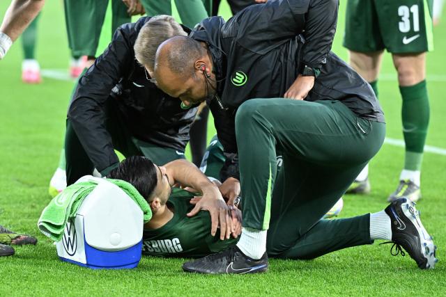 09 May 2025, Lower Saxony, Wolfsburg: Wolfsburg's Mohamed Amoura receives medical treatment on his shoulder after celebrating his goal during the German Bundesliga soccer match between VfL Wolfsburg and TSG 1899 Hoffenheim at the Volkswagen Arena. Photo: Swen Pförtner/dpa - IMPORTANT NOTICE: DFL and DFB regulations prohibit any use of photographs as image sequences and/or quasi-video.