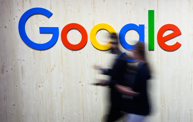 FILED - 25 April 2024, Hanover: A visitor walks past a Google stand at the Hanover technology fair. Photo: Julian Stratenschulte/dpa