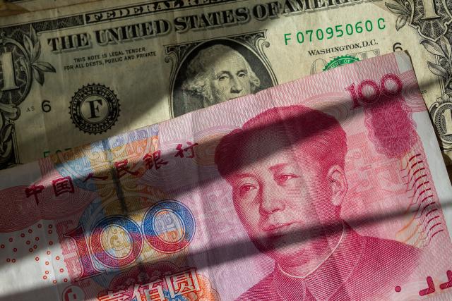 FILED - 09 April 2025, Berlin: Chinese yuan banknotes are sandwiched between several US dollar bills. Photo: Fernando Gutierrez-Juarez/dpa