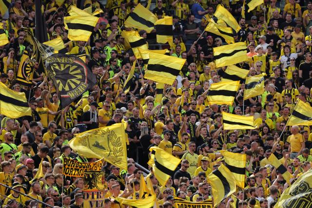 11 May 2025, North Rhine-Westphalia, Leverkusen: Dortmund fans celebrate in the stands prior to the start of the German Bundesliga soccer match between Bayer Leverkusen and Borussia Dortmund at BayArena. Photo: Rolf Vennenbernd/dpa - IMPORTANT NOTICE: DFL and DFB regulations prohibit any use of photographs as image sequences and/or quasi-video.