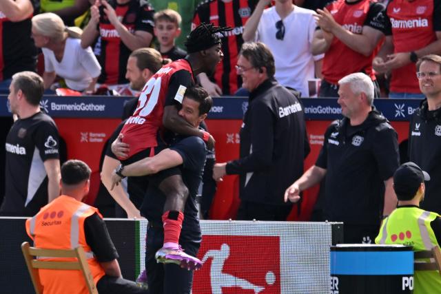 11 May 2025, North Rhine-Westphalia, Leverkusen: Leverkusen's Jeremie Frimpong celebrates scoring his side's first goal with Leverkusen coach Xabi Alonso during the German Bundesliga soccer match between Bayer Leverkusen and Borussia Dortmund at BayArena. Photo: Marius Becker/dpa - IMPORTANT NOTICE: DFL and DFB regulations prohibit any use of photographs as image sequences and/or quasi-video.