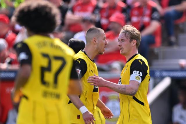 11 May 2025, North Rhine-Westphalia, Leverkusen: Dortmund's Julian Brandt (R) celebrates scoring his side's first goal with teammates during the German Bundesliga soccer match between Bayer Leverkusen and Borussia Dortmund at BayArena. Photo: Marius Becker/dpa - IMPORTANT NOTICE: DFL and DFB regulations prohibit any use of photographs as image sequences and/or quasi-video.