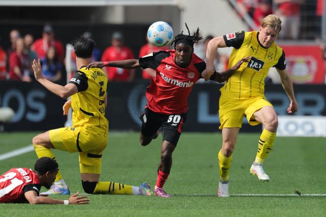 11 May 2025, North Rhine-Westphalia, Leverkusen: Dortmund's Daniel Svensson (2nd L) and Daniel Svensson battle for the ball with Leverkusen's Jeremie Frimpong (C) during the German Bundesliga soccer match between Bayer Leverkusen and Borussia Dortmund at BayArena. Photo: Rolf Vennenbernd/dpa - IMPORTANT NOTICE: DFL and DFB regulations prohibit any use of photographs as image sequences and/or quasi-video.
