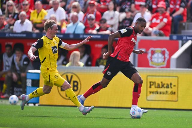 11 May 2025, North Rhine-Westphalia, Leverkusen: Dortmund's Julian Brandt (L) and Leverkusen's Jonathan Tah battle for the ball during the German Bundesliga soccer match between Bayer Leverkusen and Borussia Dortmund at BayArena. Photo: Marius Becker/dpa - IMPORTANT NOTICE: DFL and DFB regulations prohibit any use of photographs as image sequences and/or quasi-video.