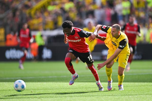 11 May 2025, North Rhine-Westphalia, Leverkusen: Leverkusen's Nathan Tella (L) and Dortmund's Waldemar Anton battle for the ball during the German Bundesliga soccer match between Bayer Leverkusen and Borussia Dortmund at BayArena. Photo: Marius Becker/dpa - IMPORTANT NOTICE: DFL and DFB regulations prohibit any use of photographs as image sequences and/or quasi-video.