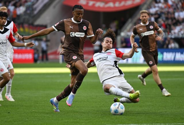 11 May 2025, Hesse, Frankfurt/Main: Frankfurt's Arthur Theate (R) and St. Pauli's Morgan Guilavogui battle for the ball during the German Bundesliga soccer match between Eintracht Frankfurt and FC St. Pauli at Deutsche Bank Park. Photo: Arne Dedert/dpa - WICHTIGER HINWEIS: Gemäß den Vorgaben der DFL Deutsche Fußball Liga bzw. des DFB Deutscher Fußball-Bund ist es untersagt, in dem Stadion und/oder vom Spiel angefertigte Fotoaufnahmen in Form von Sequenzbildern und/oder videoähnlichen Fotostrecken zu verwerten bzw. verwerten zu lassen.