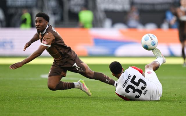 11 May 2025, Hesse, Frankfurt/Main: Frankfurt's Tuta (R) and St. Pauli's Oladapo Afolayan battle for the ball during the German Bundesliga soccer match between Eintracht Frankfurt and FC St. Pauli at Deutsche Bank Park. Photo: Arne Dedert/dpa - WICHTIGER HINWEIS: Gemäß den Vorgaben der DFL Deutsche Fußball Liga bzw. des DFB Deutscher Fußball-Bund ist es untersagt, in dem Stadion und/oder vom Spiel angefertigte Fotoaufnahmen in Form von Sequenzbildern und/oder videoähnlichen Fotostrecken zu verwerten bzw. verwerten zu lassen.