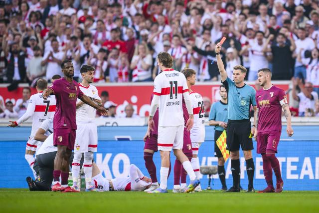 11 May 2025, Baden-Wuerttemberg, Stuttgart: Augsburg's Samuel Essende (L) is shown the red card by referee Timo Gerach during the German Bundesliga soccer match between VfB Stuttgart and FC Augsburg at MHPArena. Photo: Tom Weller/dpa - WICHTIGER HINWEIS: Gemäß den Vorgaben der DFL Deutsche Fußball Liga bzw. des DFB Deutscher Fußball-Bund ist es untersagt, in dem Stadion und/oder vom Spiel angefertigte Fotoaufnahmen in Form von Sequenzbildern und/oder videoähnlichen Fotostrecken zu verwerten bzw. verwerten zu lassen.