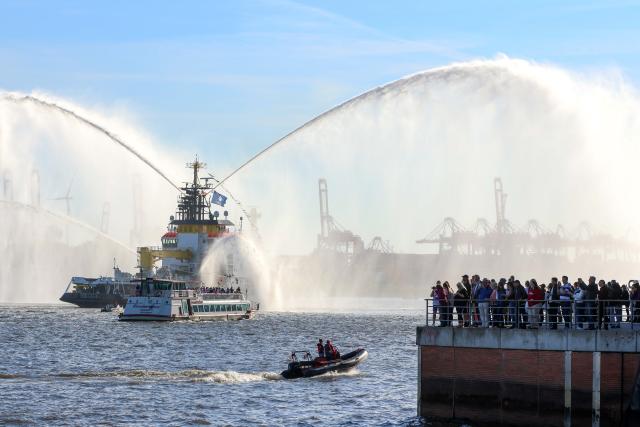 11 May 2025, Hamburg: Spectators at the port watch the departure parade at the end of the 836th Hamburg Port Birthday, including the multi-purpose ship "Neuwerk". Photo: Bodo Marks/dpa