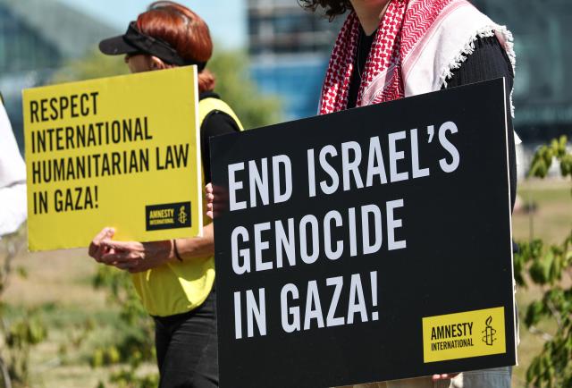 12 May 2025, Berlin: Participants in an Amnesty International protest against the Israeli war in the Gaza Strip hold signs in front of the Federal Chancellery. The Israeli President visits Germany to mark the establishment of diplomatic relations between the Federal Republic of Germany and Israel 60 years ago. Photo: Hannes P. Albert/dpa