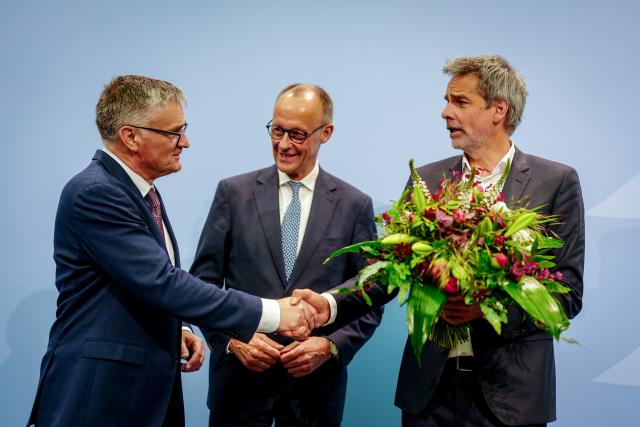12 May 2025, Berlin: Steffen Hebestreit (R), former Federal Government Spokesman and Head of the Federal Government Information Office, hands over his office to his successor Stefan Kornelius (L), German Federal Government Spokesman, next to Federal Chancellor Friedrich Merz in the Federal Government Information Office. Photo: Kay Nietfeld/dpa