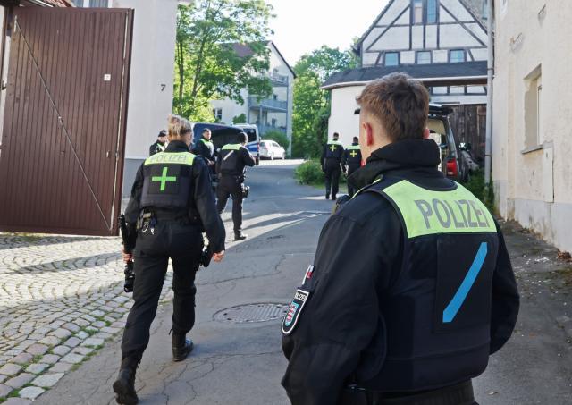 13 May 2025, Thuringia, Gera: Police officers search buildings following the ban of the Reichsbuerger group "Kingdom of Germany" by the German Minister of the Interior. "Reich Citizens" do not recognize the Federal Republic of Germany as a state. The police searched buildings in Baden-Württemberg, Lower Saxony, North Rhine-Westphalia, Rhineland-Palatinate, Saxony, Saxony-Anhalt and Thuringia. Photo: Bodo Schackow/dpa