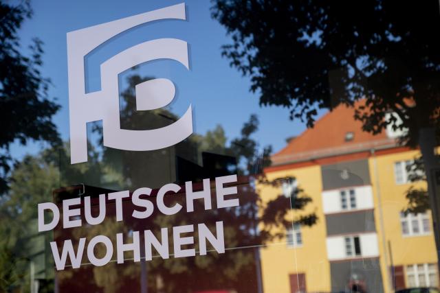 FILED - 16 August 2020, Berlin: The logo of housing company Deutsche Wohnen is reflected in a window at the Hufeisensiedlung estate in Berlin-Neukoelln. Photo: Christoph Soeder/dpa