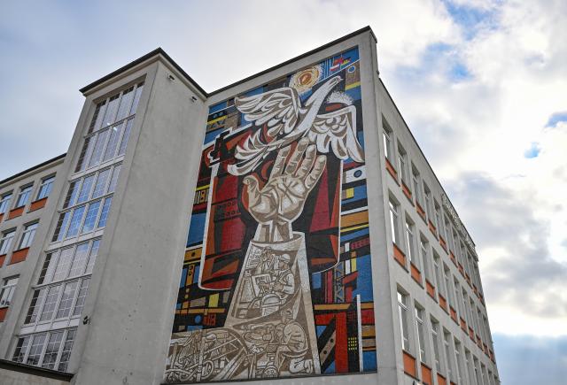 FILED - 14 February 2023, Brandenburg, Eisenhuettenstadt: A large mosaic artwork by Walter Womacka seen on the facade of a former department store. An eastern German city is offering two weeks of free lodgings in a bid to attract new residents as it continues to grapple with depopulation some 35 years after reunification. Photo: Patrick Pleul/dpa