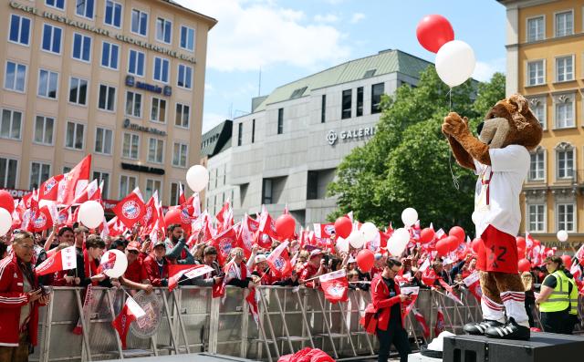 18 May 2025, Bavaria, Munich: FC Bayern Munich fans wait with mascot "Berni" on Marienplatz for the start of the championship celebrations Photo: Daniel Löb/dpa