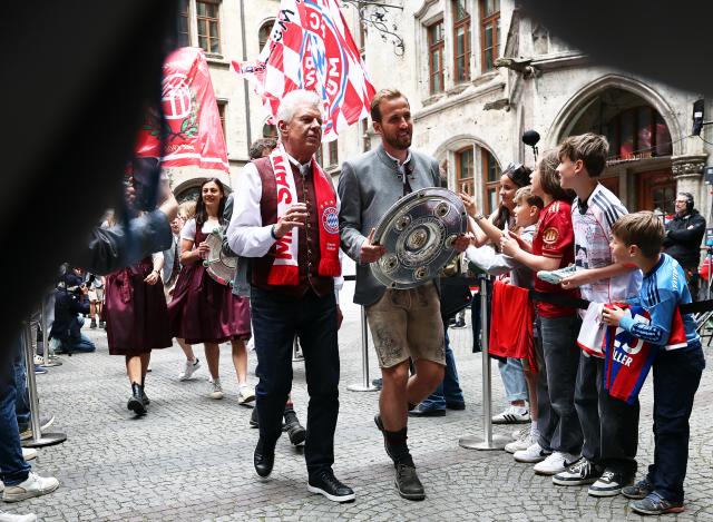 18 May 2025, Bavaria, Munich: Bayern Munich footballer Harry Kane (C-R) holds the German Bundesliga trophy as he arrives with Dieter Reiter (C-L), Lord Mayor of Munich, at the championship celebrations of Bayern Munich. Photo: Daniel Löb/dpa