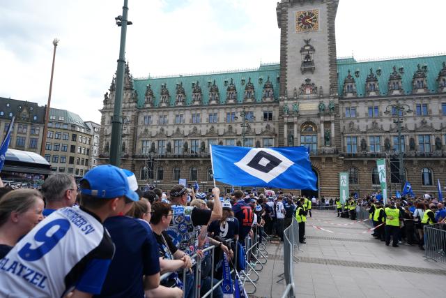 19 May 2025, Hamburg: Hamburger fans wait at the Rathausmarkt in front of Hamburg City Hall to celebrate their club's promotion to the 1st Bundesliga. Photo: Marcus Brandt/dpa