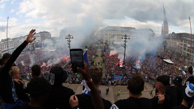 19 May 2025, Hamburg: The HSV players greet their fans from the balcony in front of Hamburg City Hall to celebrate their club's promotion to the 1st Bundesliga. Photo: Christian Charisius/dpa