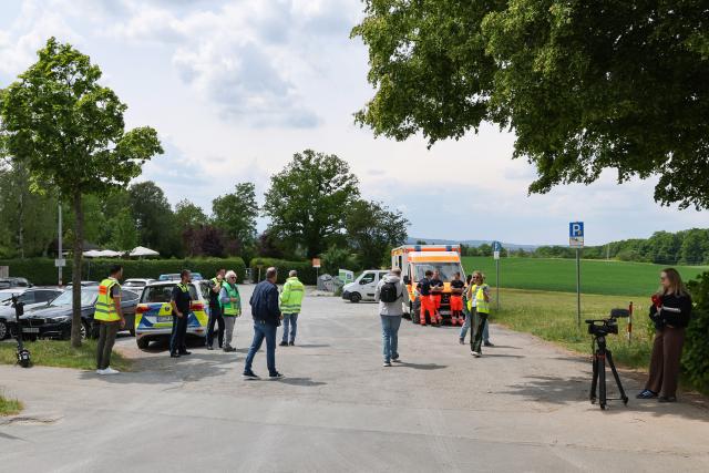 21 May 2025, Bavaria, Bayreuth: Police and emergency services stand in a parking lot near the secondary school. A pupil had found an American hand grenade from the Second World War, which was safely detonated by a demolition team. Photo: Daniel Löb/dpa