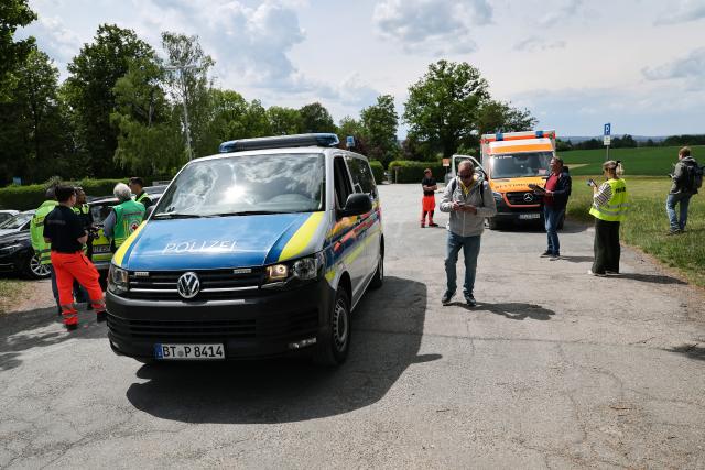 21 May 2025, Bavaria, Bayreuth: Police and emergency services stand in a parking lot near the secondary school. A pupil had found an American hand grenade from the Second World War, which was safely detonated by a demolition team. Photo: Daniel Löb/dpa