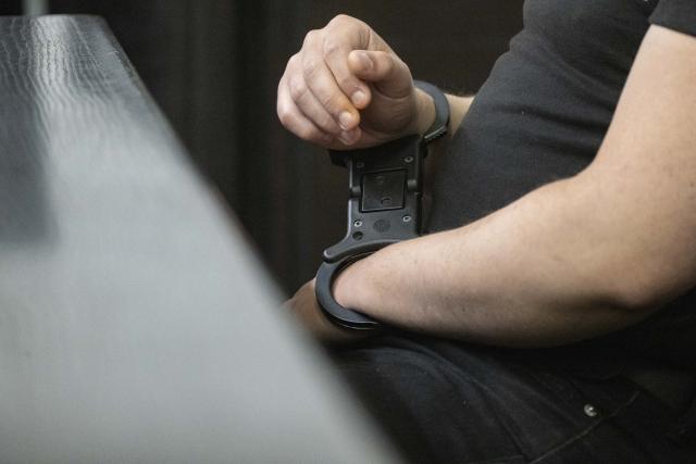 22 May 2025, Baden-Württemberg, Stuttgart: A defendant in custody, accused of making bomb threats against schools, sits in a courtroom at Stuttgart Regional Court. The two accused young men are alleged to have sent bomb threats to several facilities and institutions in October and November 2023, including the University of Stuttgart, the Israelite community in Ulm, the Heilbronn district office, the KIT in Karlsruhe and the police academy in Villingen-Schwenningen. Photo: Marijan Murat/dpa