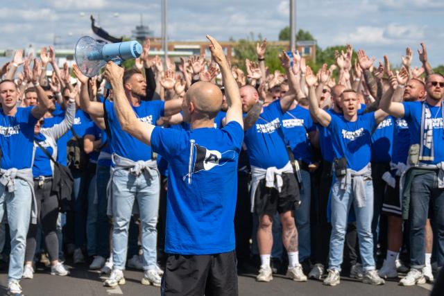24 May 2025, Berlin: Bielefeld fans march from Heerstrasse to the Olympic Stadium, ahead of the German DFB Cup final soccer match against Stuttgart. Photo: Christophe Gateau/dpa