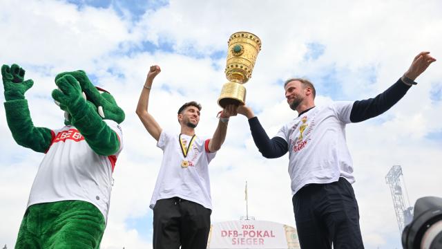 25 May 2025, Baden-Wuerttemberg, Stuttgart: Stuttgart's Atakan Karazor (C) and Stuttgart coach Sebastian Hoeness (R) celebrate with the trophy at the reception on the Schlossplatz after winning the final aginst Arminia Bielefeld. Photo: Uli Deck/dpa