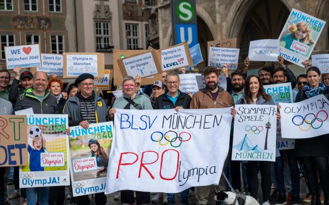 28 May 2025, Bavaria, Munich: Several people take part in a demonstration on Marienplatz in support of Munich's planned Olympic bid and hold placards. A banner in the middle reads: "BLSV Munich - PROlympia". The demonstration was organized by the Bavarian State Sports Association and Allianz Munich. Photo: Leonie Asendorpf/dpa